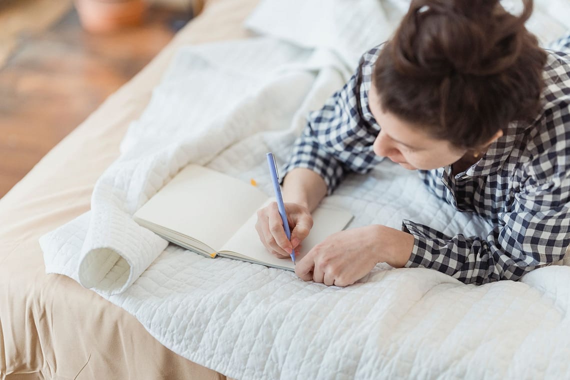 woman journaling in bed