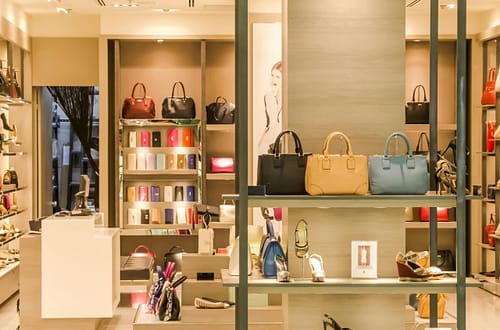 Chic boutique with a variety of handbags and shoes elegantly displayed on shelves.